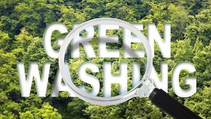 Alert to Greenwashing - concept with text against a forest and trees and magnifying glass