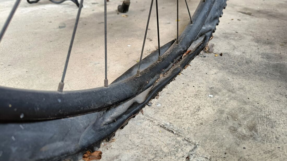 Flat old dusty bike tire on ground