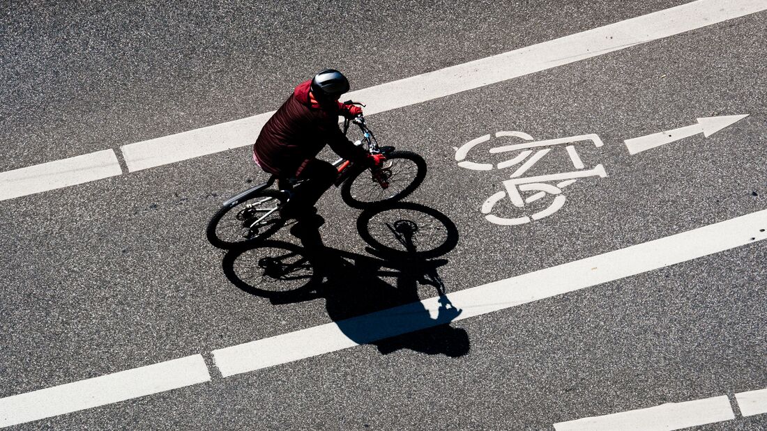 High Angle View Of Man Cycling On Bicycle Lane During Sunny Day