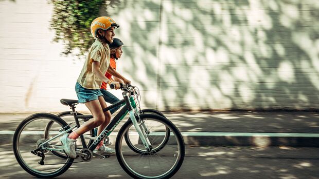 Zwei Mädchen fahren auf ihren Woom Bikes